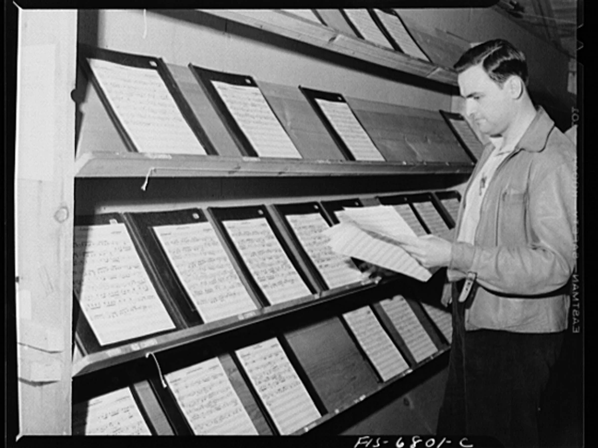 Young musicians collecting score sheets from racks in the Interlochen music library in 1942.