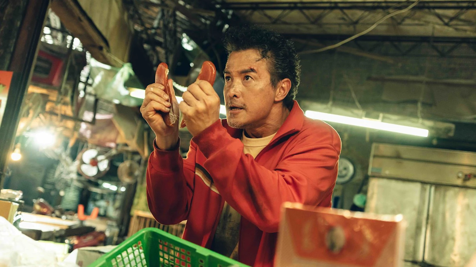 Christopher Lee holds two sausages in a market scene from The Fixers.