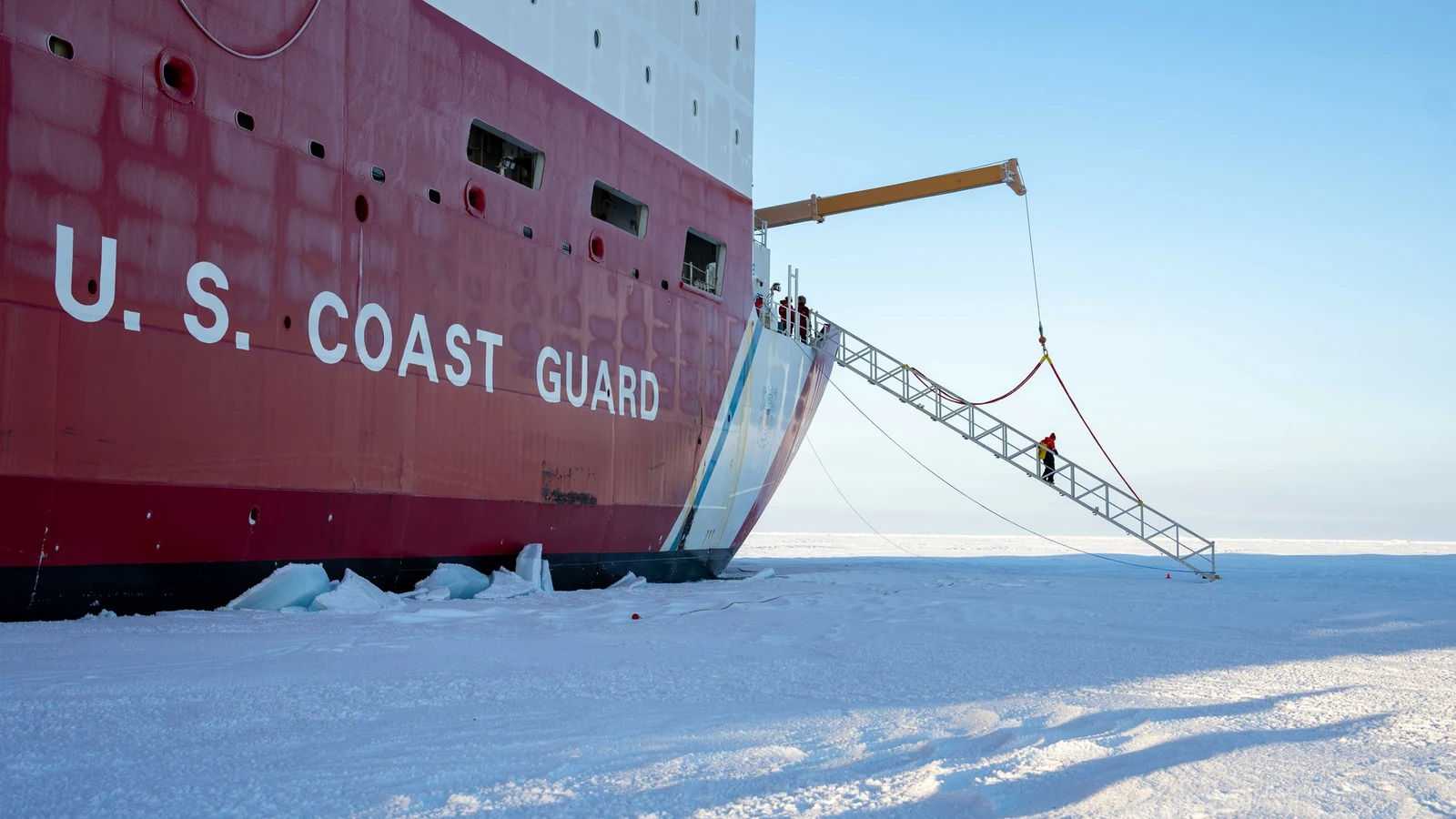 The Coast Guard Cutter Healy rests against Arctic sea ice with a gangway lowered.