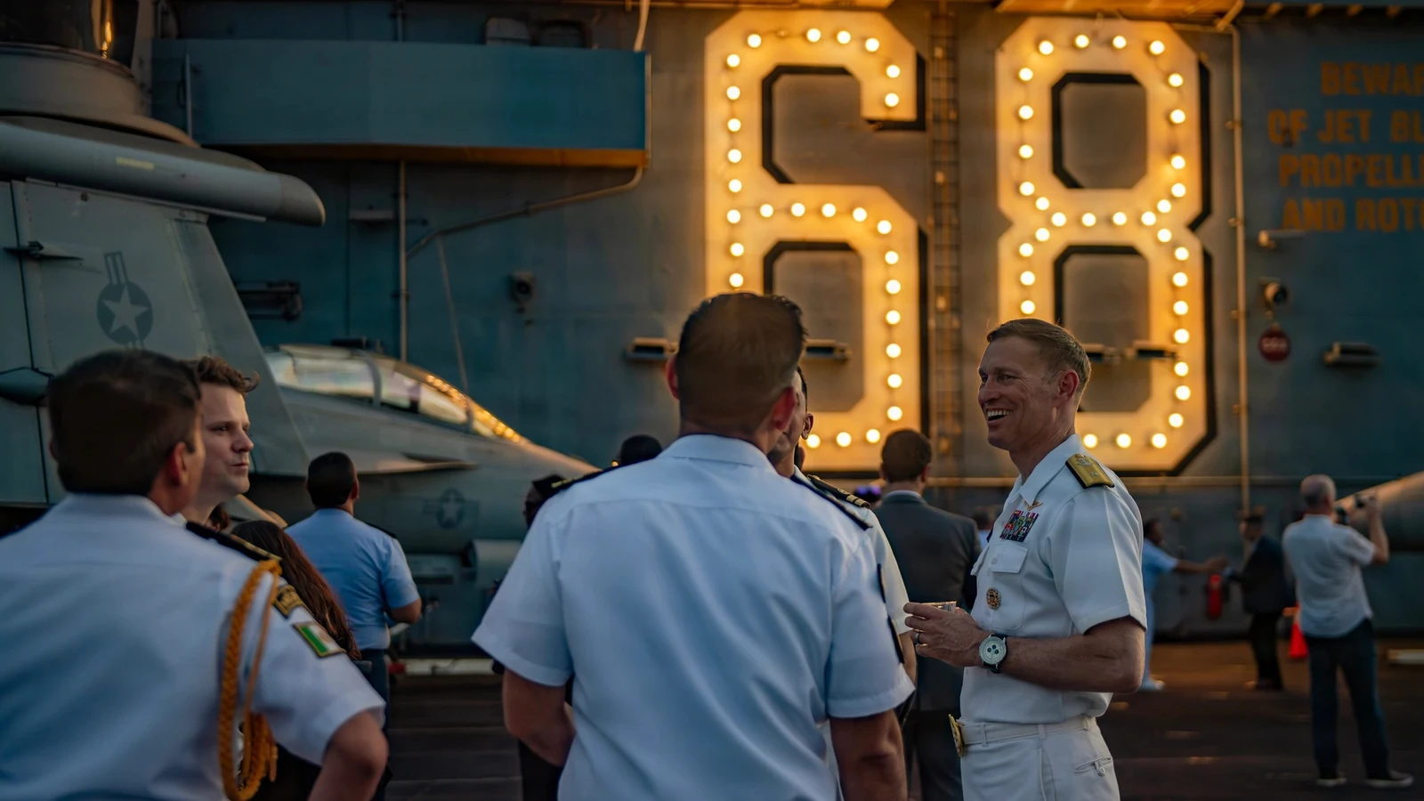 Brazilian guests and U.S. Navy officers speak at a reception on a ship off Rio de Janeiro.