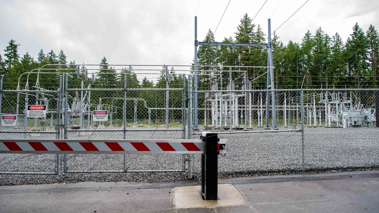 A fenced electrical substation stands beneath high-voltage power lines in Washington state.