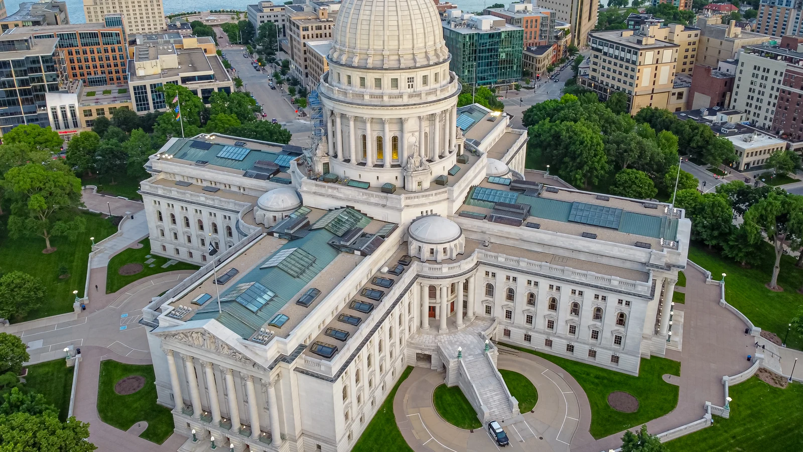The white-domed Wisconsin State Capitol rises above downtown Madison at dusk.