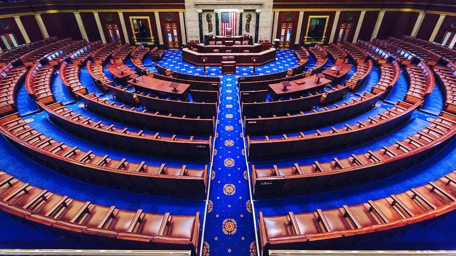 The empty U.S. House chamber viewed from the gallery, with the Speaker's rostrum and voting boards visible.