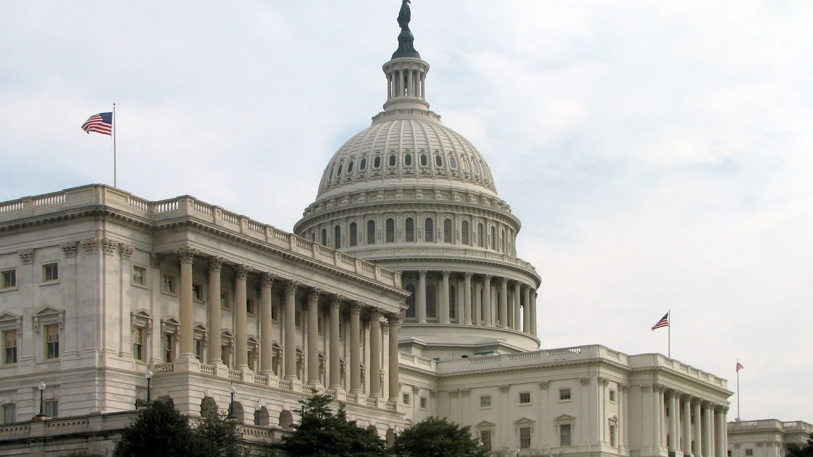 The Senate wing of the United States Capitol beneath a blue sky.