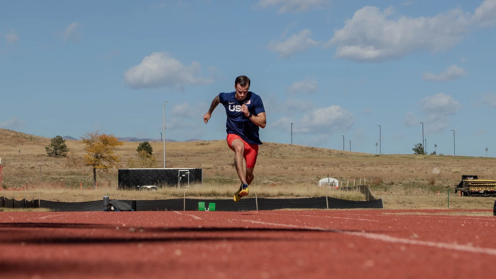A competitive sprinter accelerates around a track curve during training.