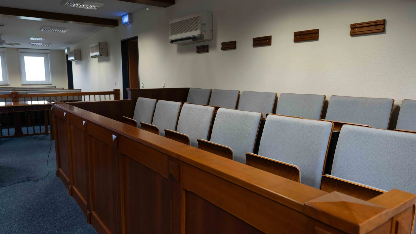 An empty trial courtroom shows the judge’s bench, witness stand, counsel tables and gallery.