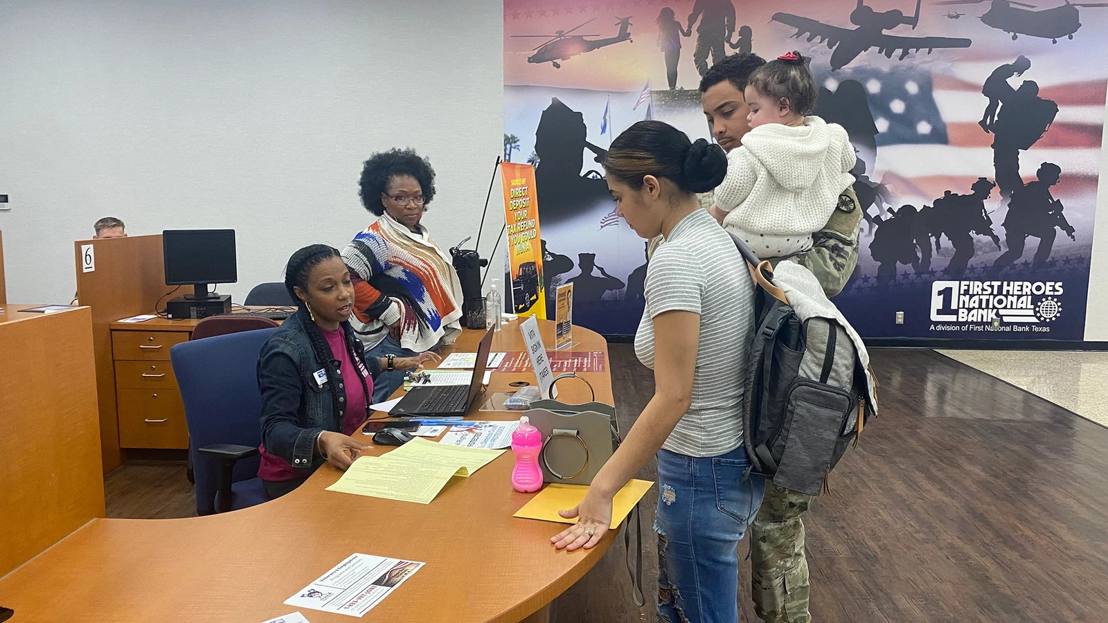 A family checks in with a volunteer at a free tax-preparation assistance desk.