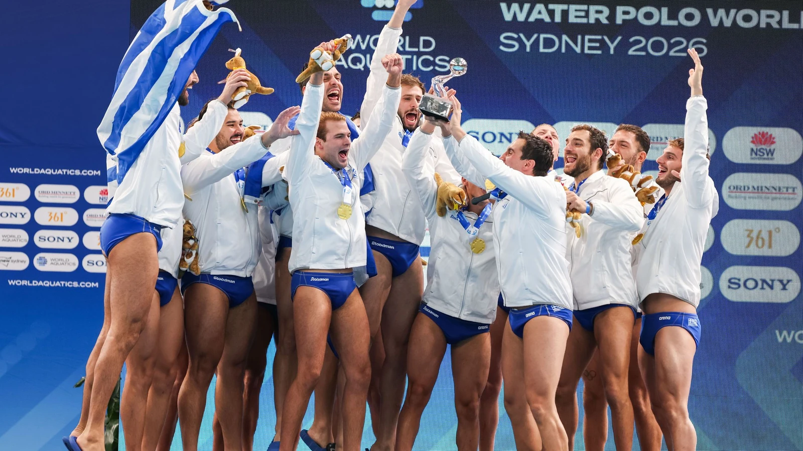 Greece’s men’s water-polo team celebrates together in the pool while raising the World Cup trophy.