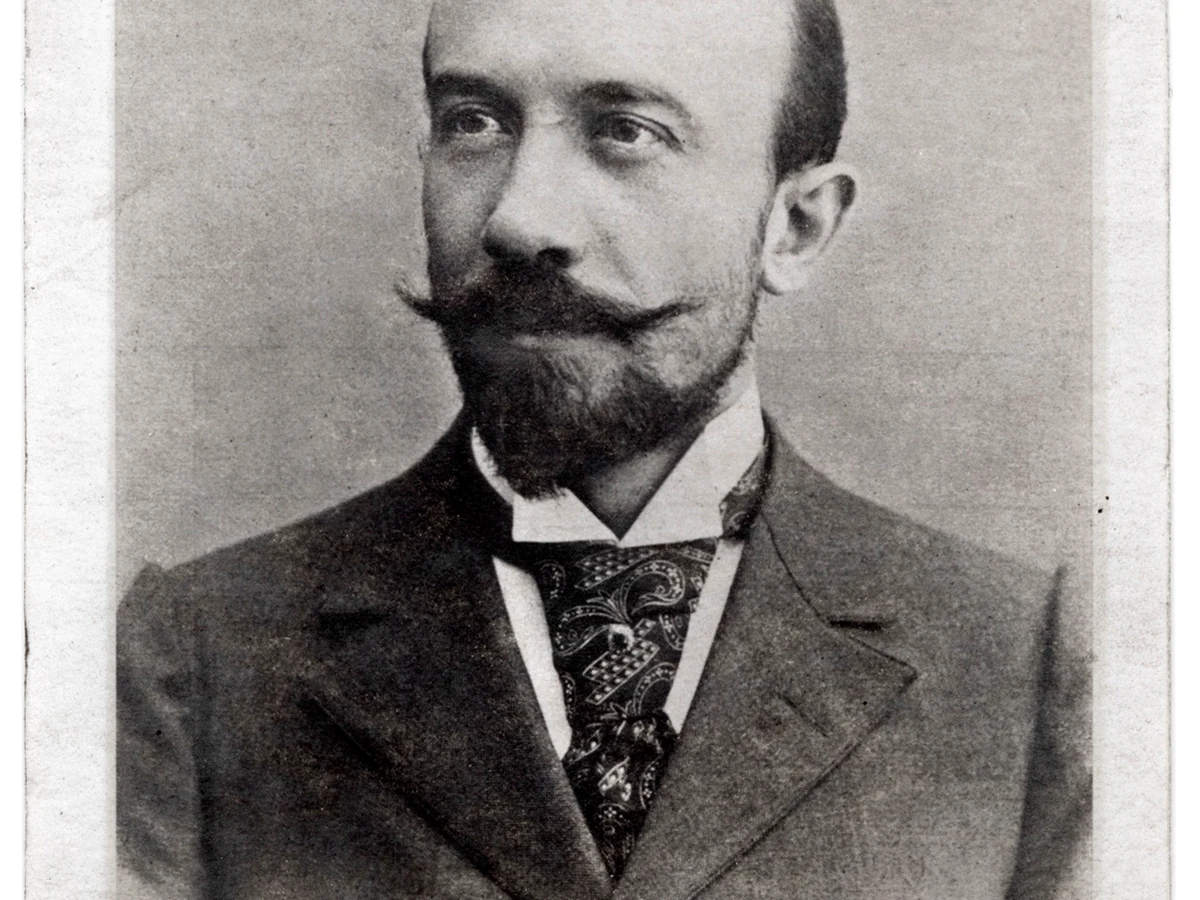 A formal black-and-white portrait shows filmmaker and magician Georges Méliès at about age 34.