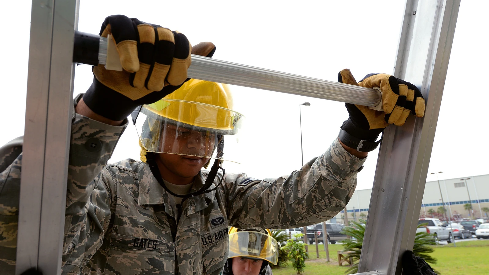 A firefighter climbs a tall ladder during a training exercise.