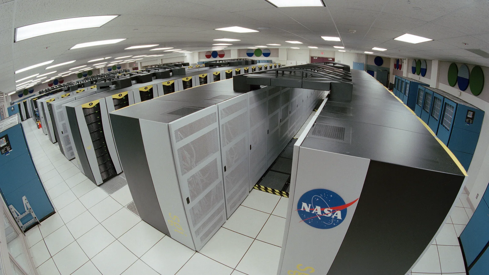 Rows of illuminated computing cabinets inside NASA's Advanced Supercomputing facility.