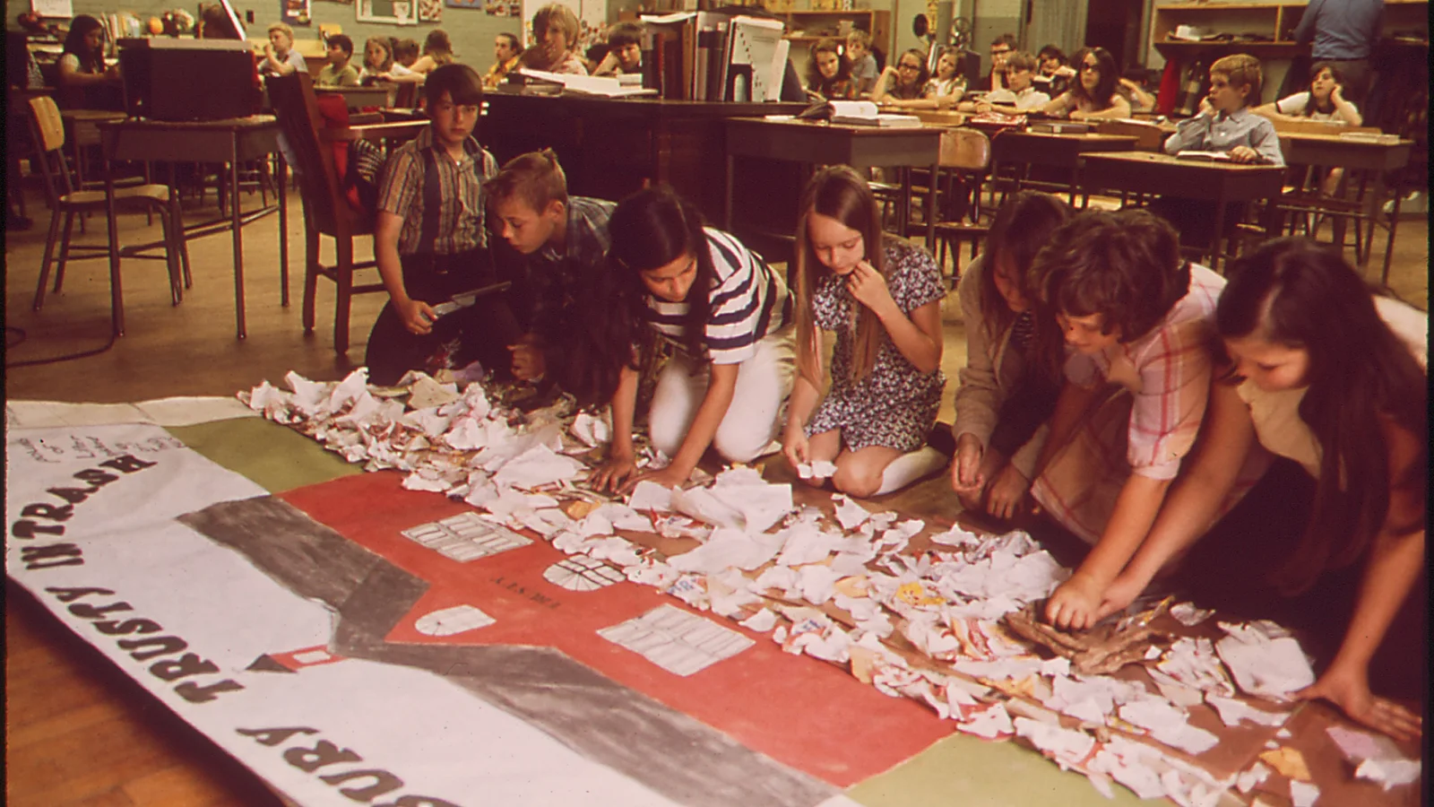 Students and a teacher work together at tables in an Arkansas classroom.