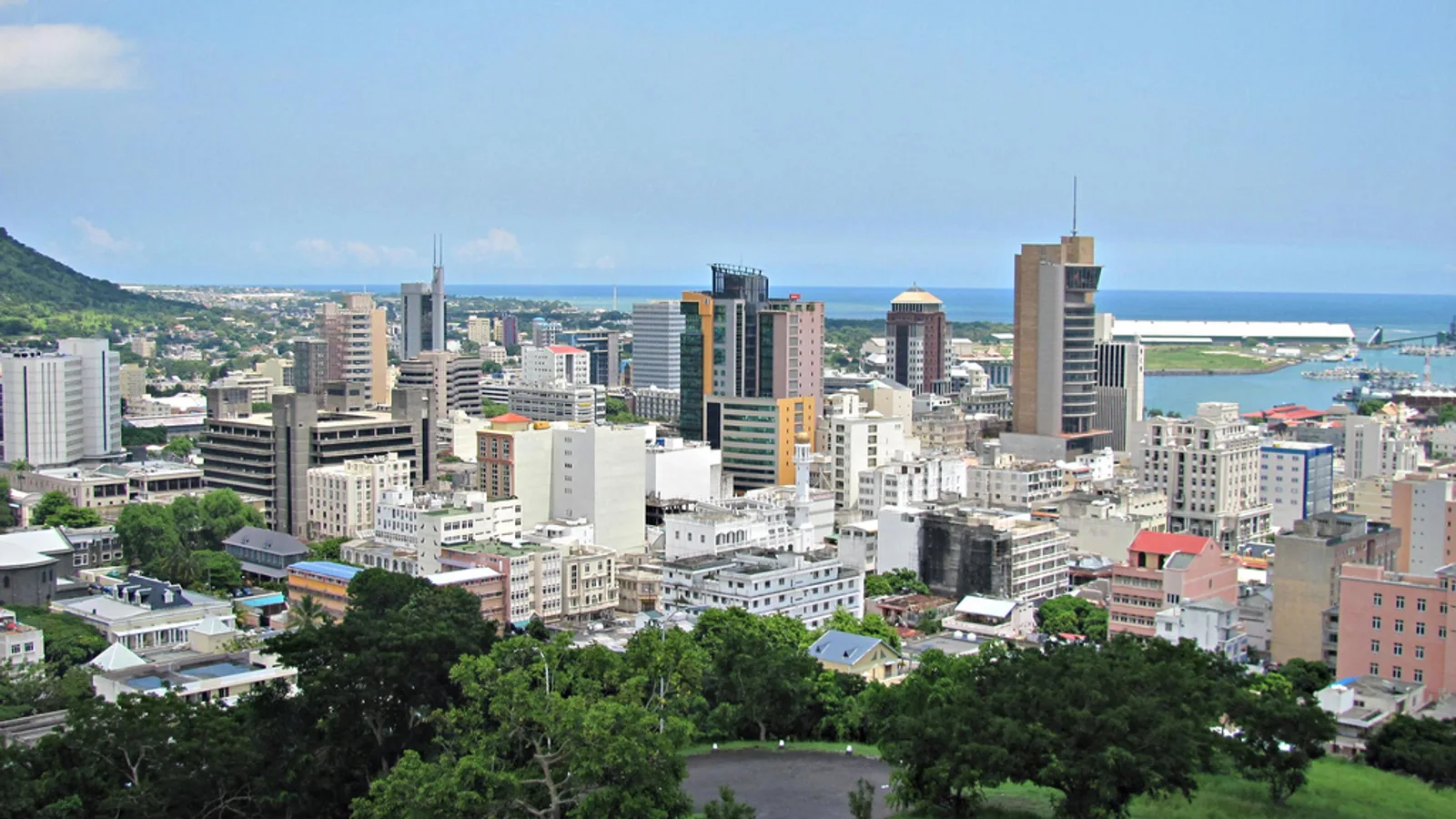 Port Louis waterfront and city buildings beneath green mountains.