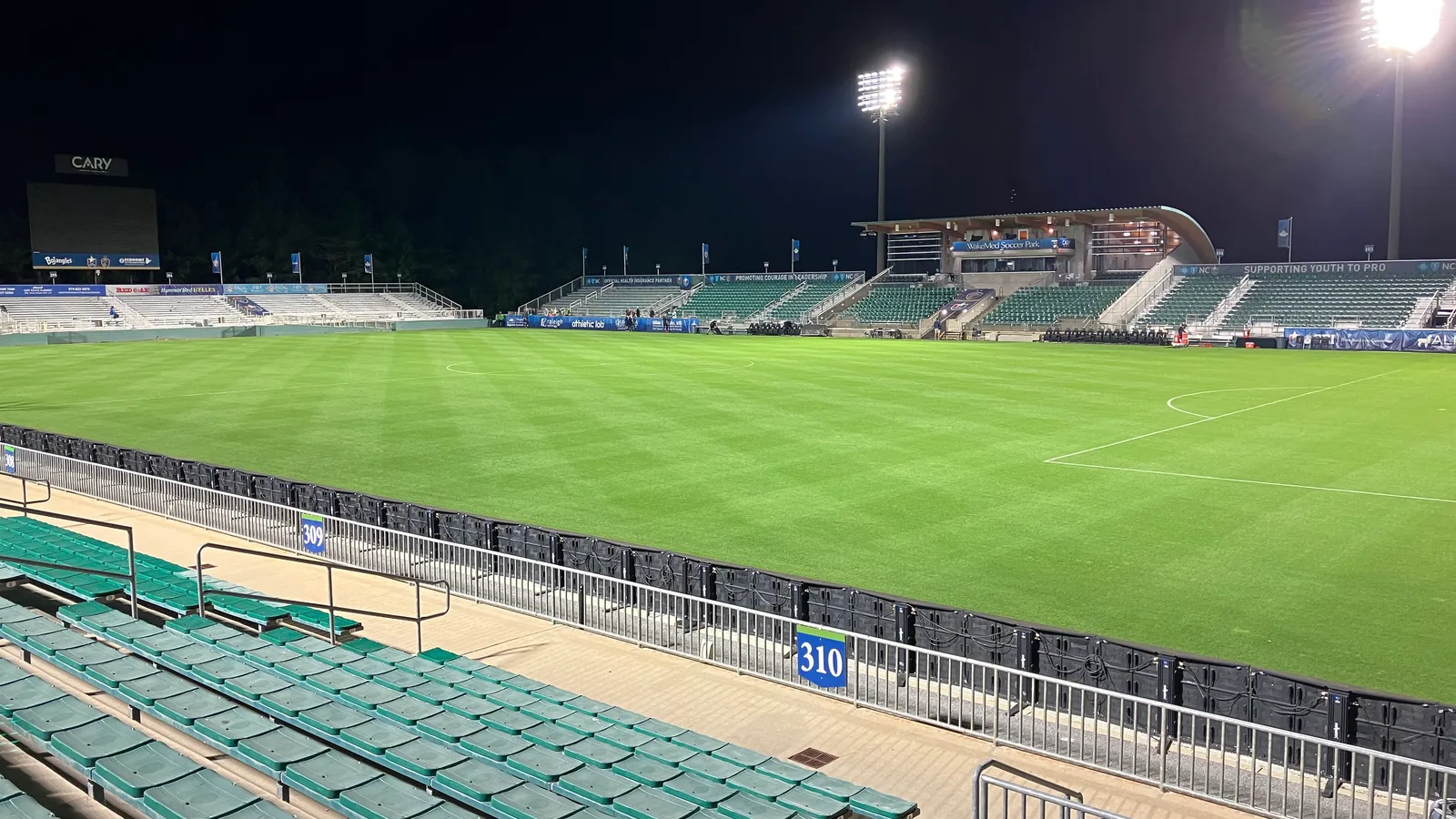 Women's soccer match under stadium lights at WakeMed Soccer Park.