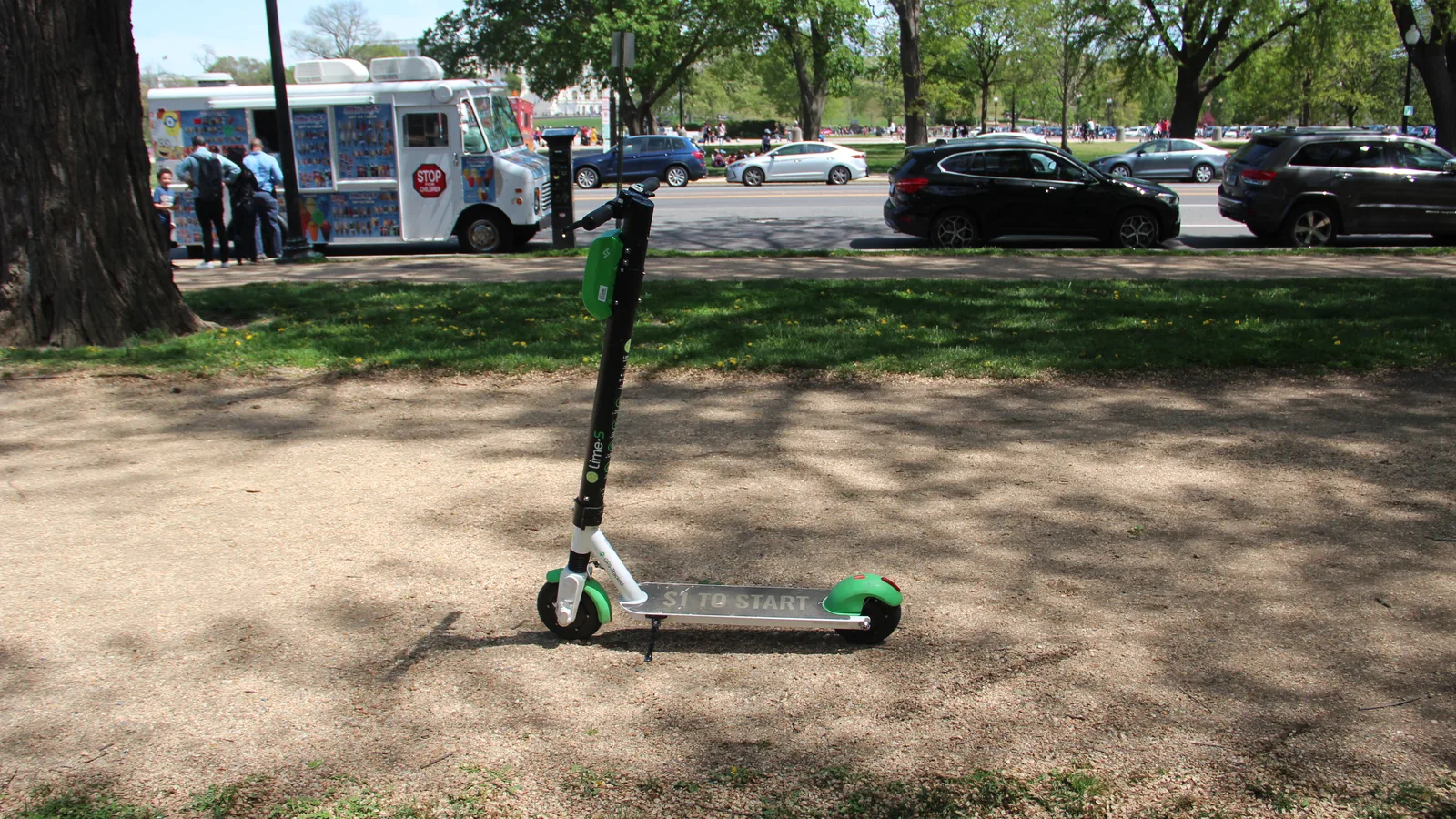 Green electric scooter parked beside a walkway on the National Mall in Washington.