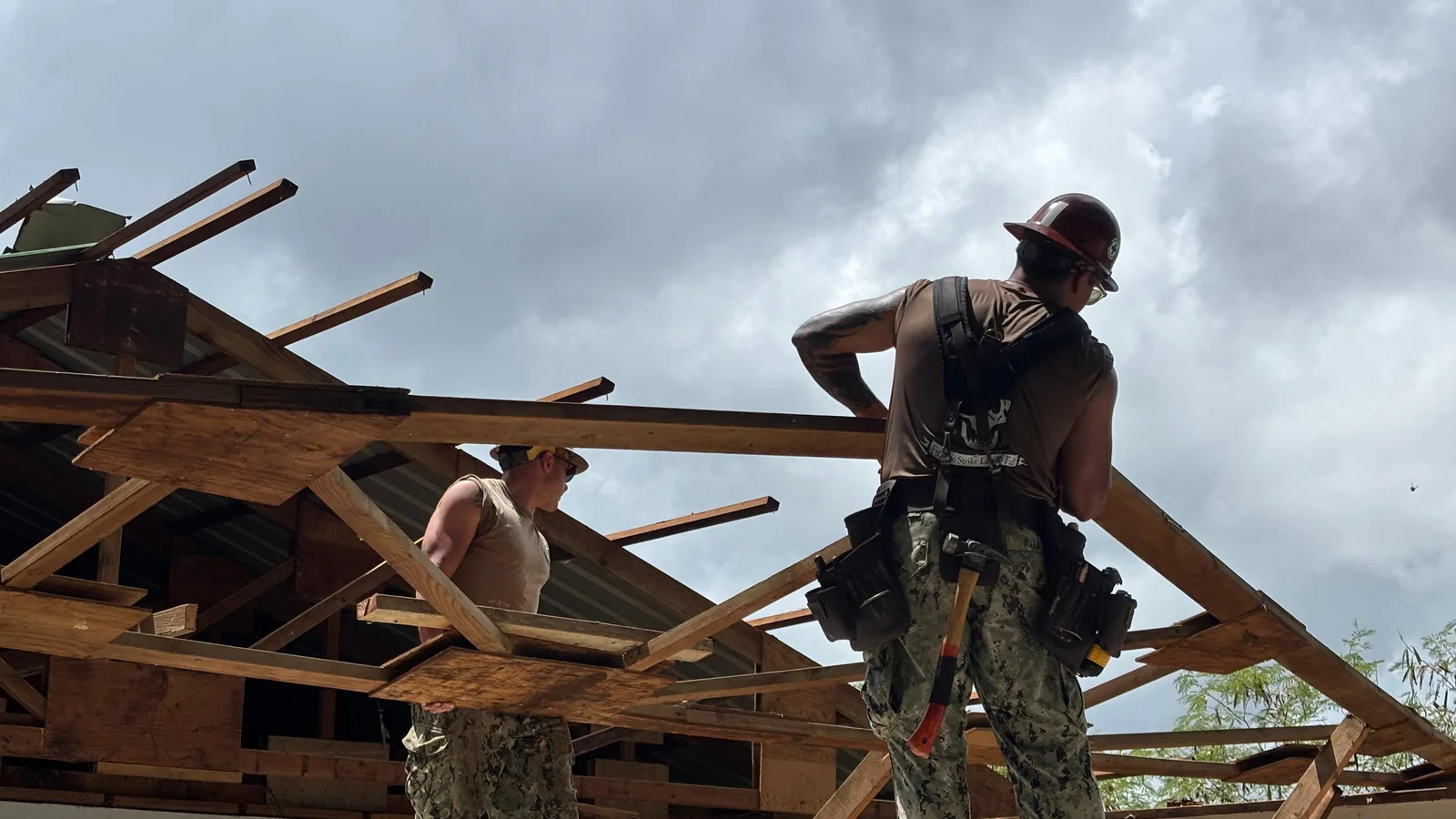 Construction workers repair the roof of a school building in Pohnpei.