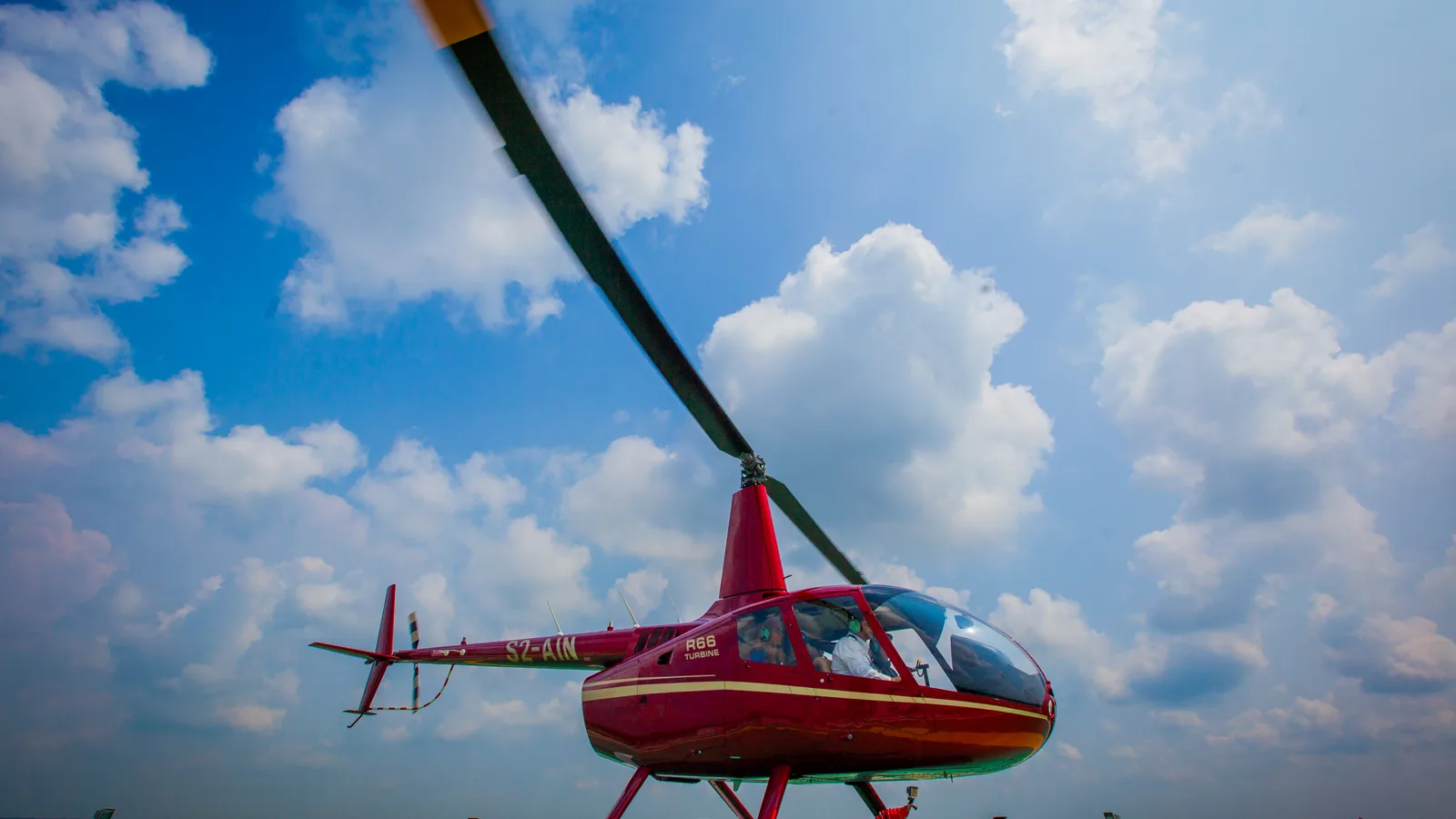 Robinson R66 helicopter parked on an airfield apron.