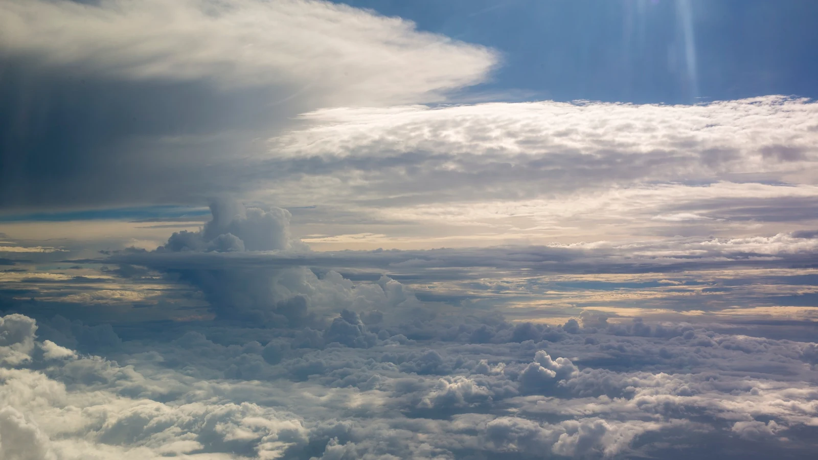 A massive dark storm cloud rises above the Gulf of Mexico, seen from an aircraft.