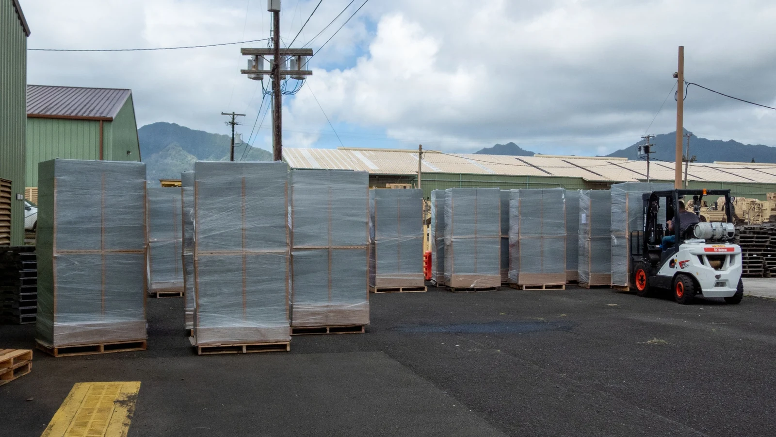 Pallets of new dressers are unloaded for delivery to Army barracks.