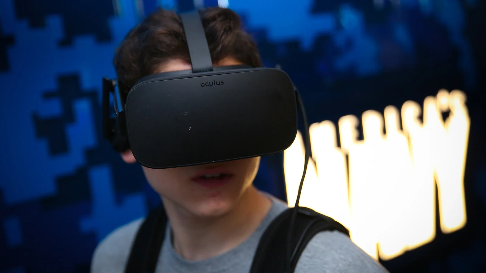 A high school student wears a virtual-reality headset while using an immersive Navy STEM simulator.