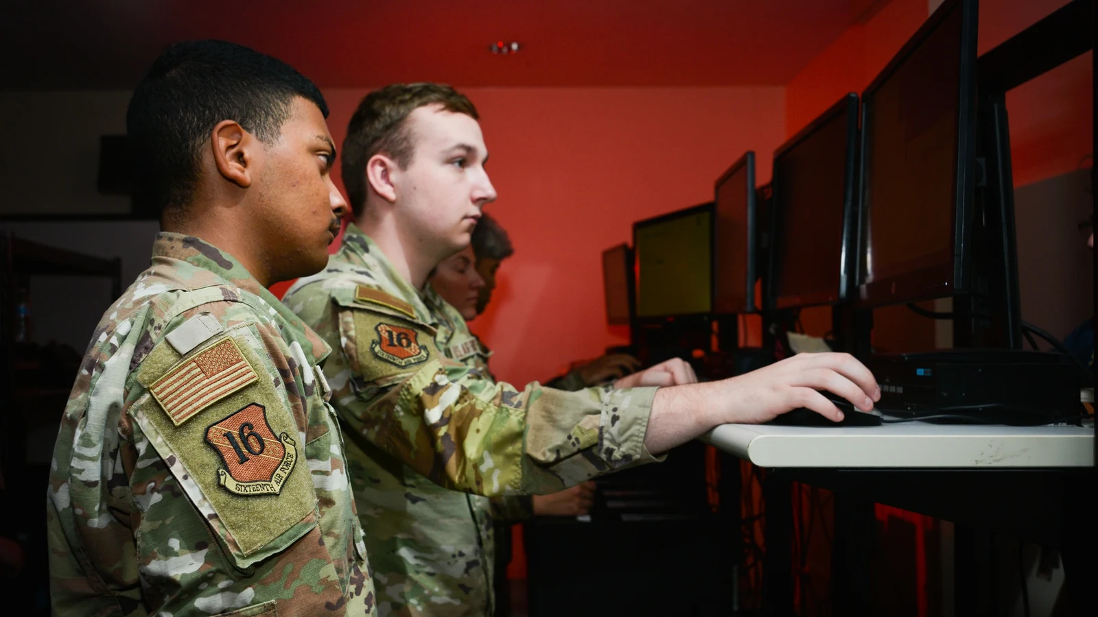 Two Air Force information-technology specialists examine equipment in a server room.