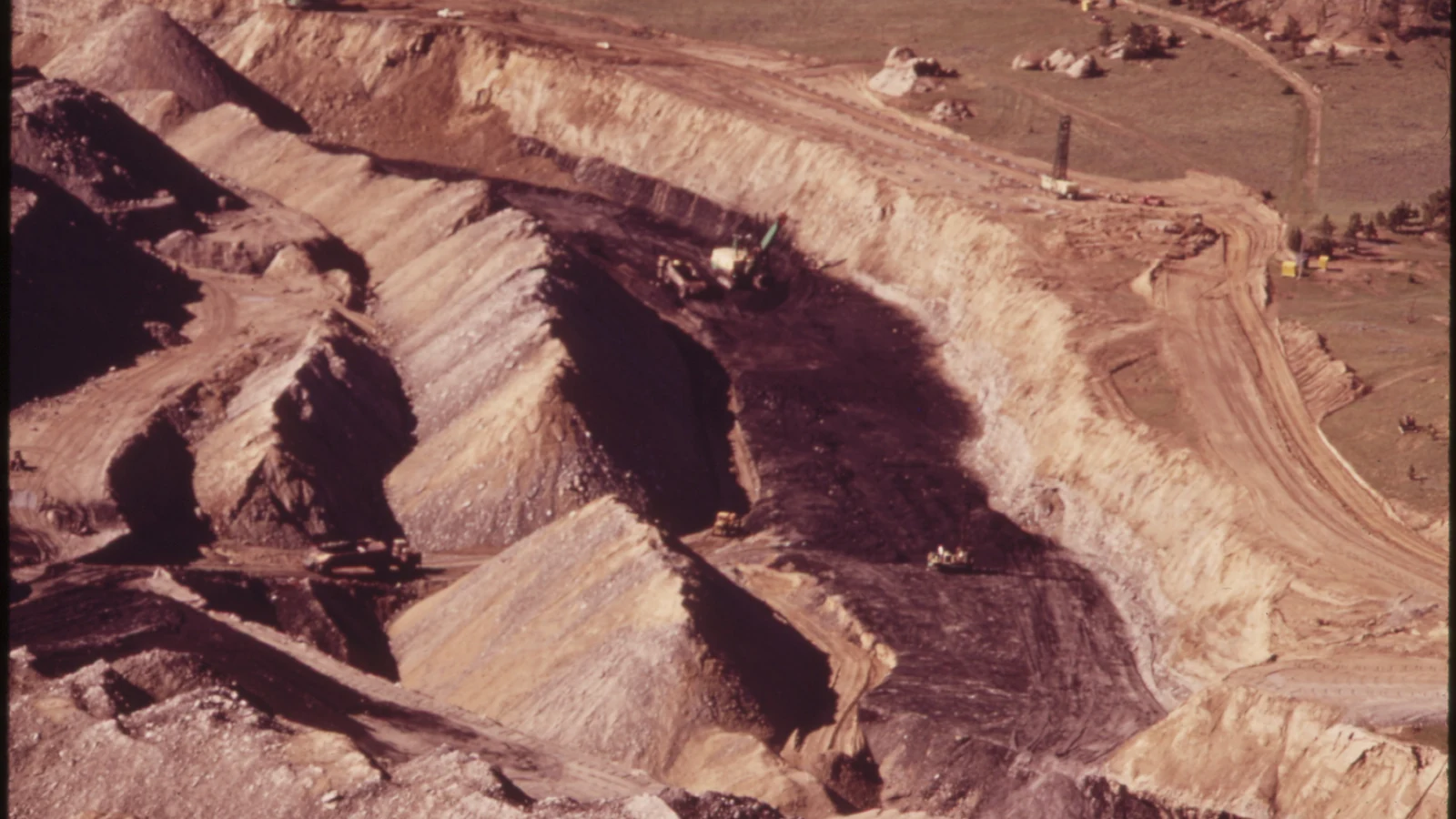Archival aerial view of terraced cuts and machinery at a strip mine near Colstrip, Montana.