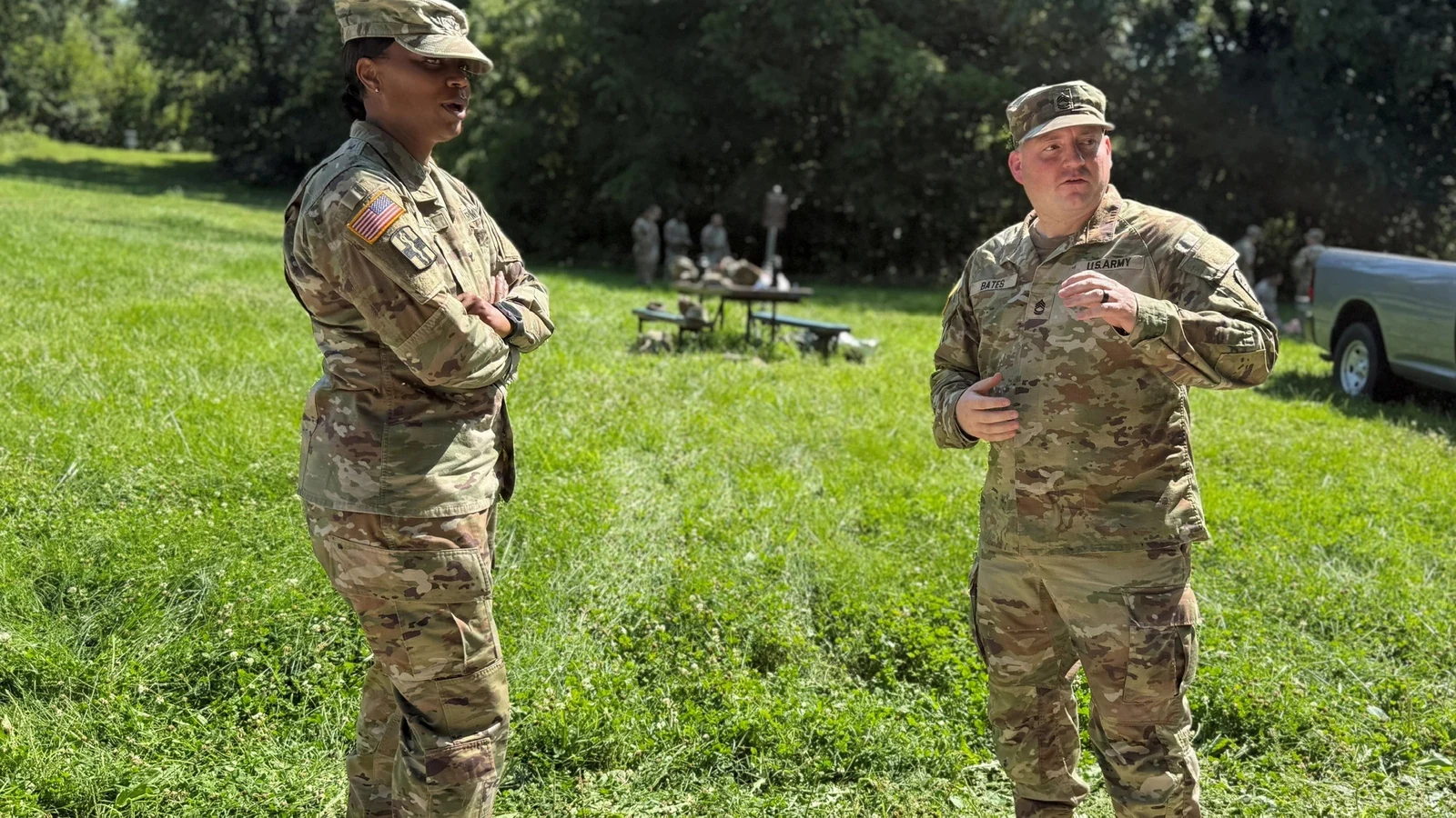Two soldiers stand in intense sunlight during summer outdoor training at Fort Leavenworth.