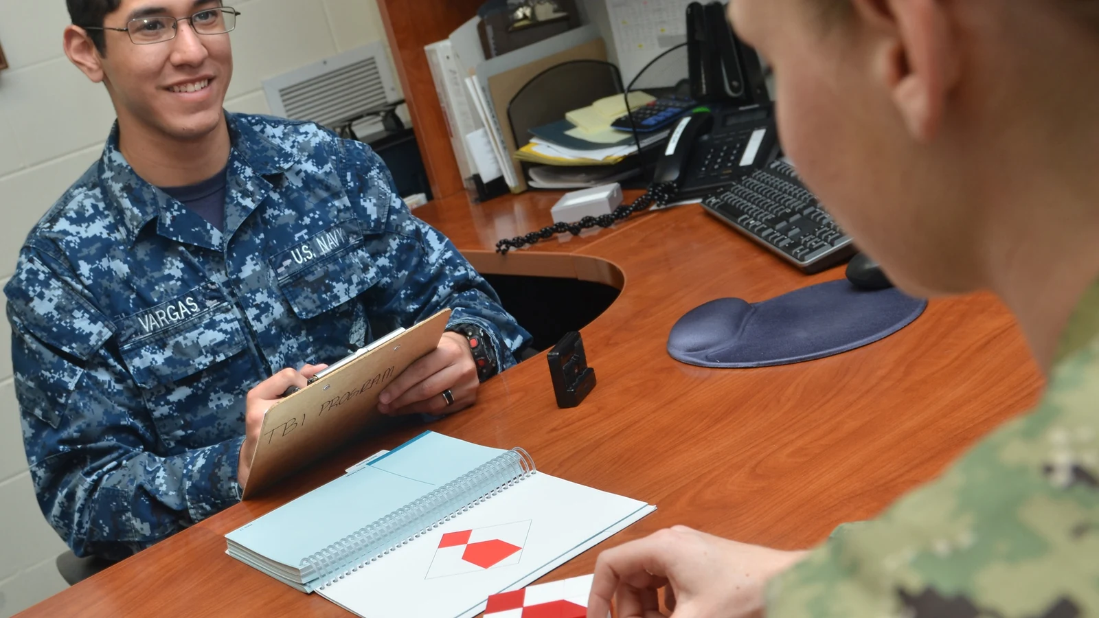 A health technician guides a patient through a block-design cognitive assessment.